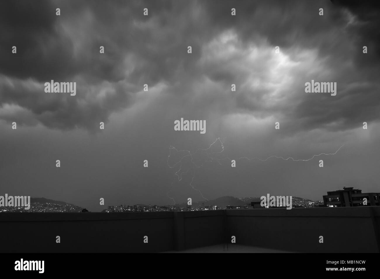 Nuvole di tempesta e fulmini al crepuscolo in Quito Foto Stock