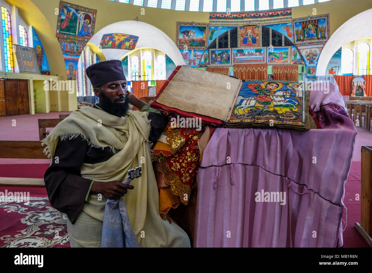 Aksum, Etiopia - 12 Gennaio 2018: Unidentified uomo dimostra antica la Bibbia in amarico lingua nella chiesa di Nostra Signora di Sion in Aksum. Foto Stock