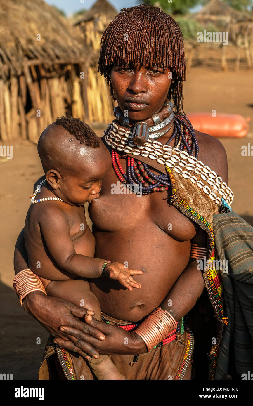 Turmi, Etiopia - Gennaio 25, 2018: Unidentified Hamer tribe donna con suo figlio. Hamer donna pettine di solito i loro capelli con terreno in Turmi, Etiopia. Foto Stock