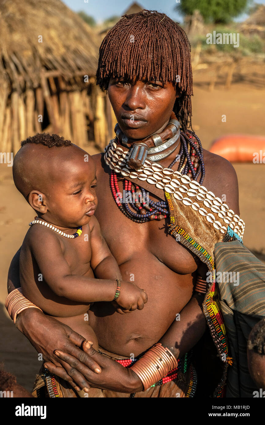 Turmi, Etiopia - Gennaio 25, 2018: Unidentified Hamer tribe donna con suo figlio. Hamer donna pettine di solito i loro capelli con terreno in Turmi, Etiopia. Foto Stock