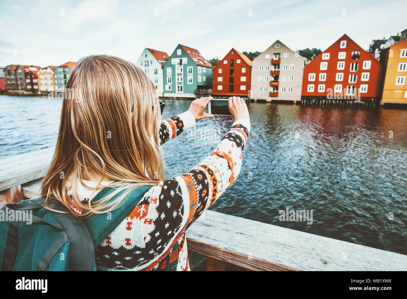 Traveler donna prendendo foto tramite smartphone Sightseeing della città di Trondheim in Norvegia Lifestyle vacanze outdoor scandinavian case colorate landmarks arch Foto Stock