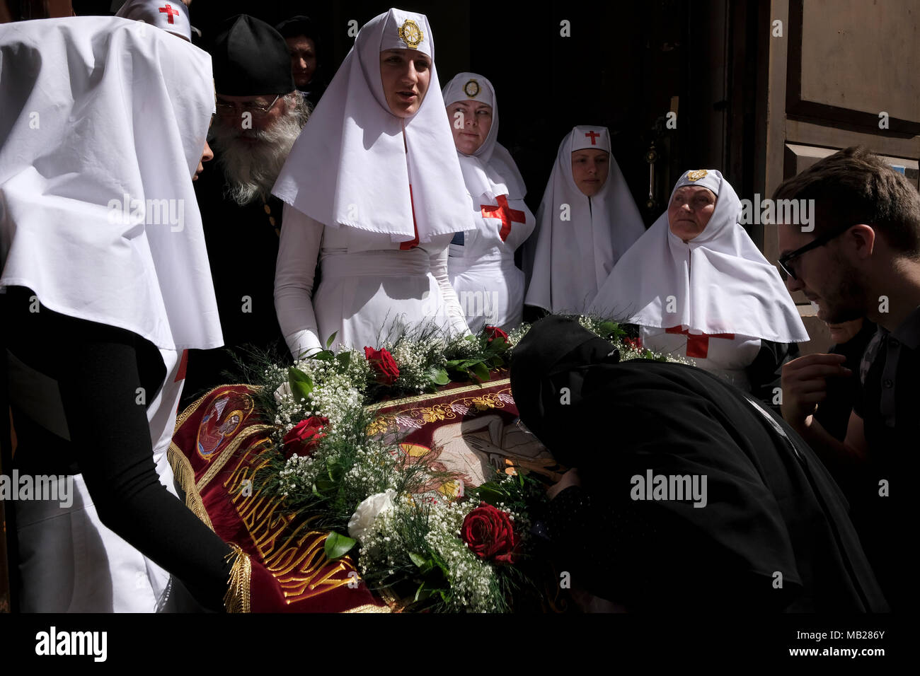 Gerusalemme, Israele 6 Aprile 2018: un ortodosso orientale pellegrino baciare l'icona di Gesù Cristo visualizzata alla porta della chiesa russo-ortodossa di San Alexander Nevsky nel quartiere cristiano durante il Venerdì Santo della chiesa ortodossa la settimana santa nella Città Vecchia di Gerusalemme Est Israele. I cristiani ortodossi di tutto il mondo commemorano eventi intorno la crocifissione di Gesù Cristo, che conduce fino alla sua resurrezione di Pasqua. Credito: Eddie Gerald/Alamy Live News Foto Stock