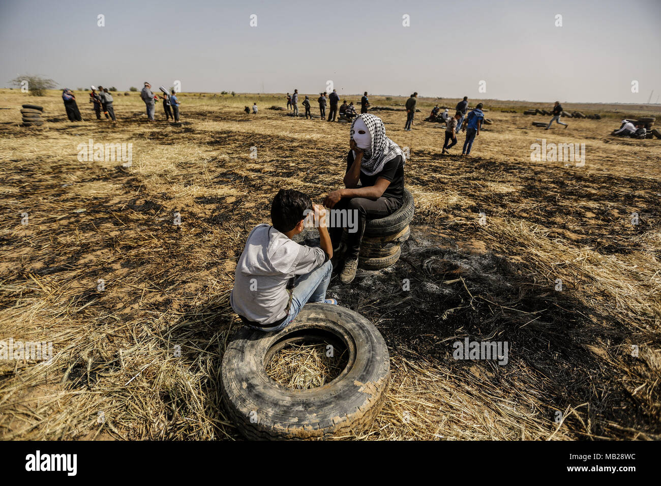 Khan Younis, sud della striscia di Gaza, 06 aprile 2018. I dimostranti palestinesi sedersi sulle gomme, durante una tendopoli protesta lungo il confine Israel-Gaza, rivendicano il diritto di tornare in patria, in Khan Younis, sud della striscia di Gaza, 06 aprile 2018. Migliaia di palestinesi sono in marcia verso la zona di confine per la seconda settimana di un periodo di sei settimane di protesta lungo doppiato il 'Grande marzo del ritorno' lungo il confine Gaza-Israel. Credito: dpa picture alliance/Alamy Live News Foto Stock