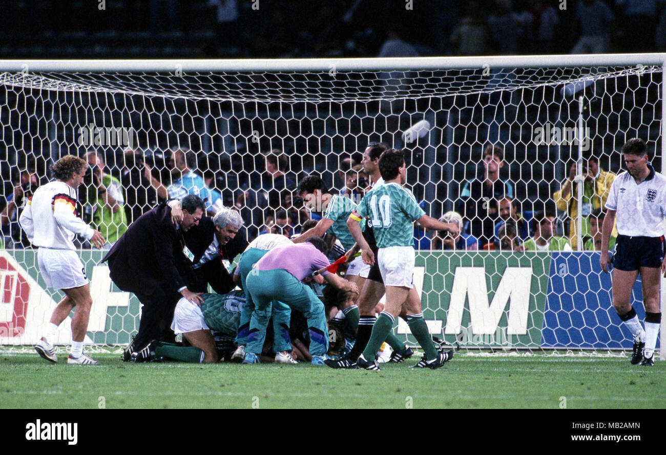 Coppa del Mondo FIFA - Italia 1990 (Italia 1990) 4.7.1990, Stadio Delle Alpi, Torino, Italia. Semi-finale Germania Ovest v Inghilterra. I giocatori tedeschi celebrare la vittoria sulle sanzioni da palificate sulla parte superiore delle portiere Bodo Illgner. Sulla destra Lothar Matthes passeggiate in Inghilterra Chris Waddle. Foto Stock