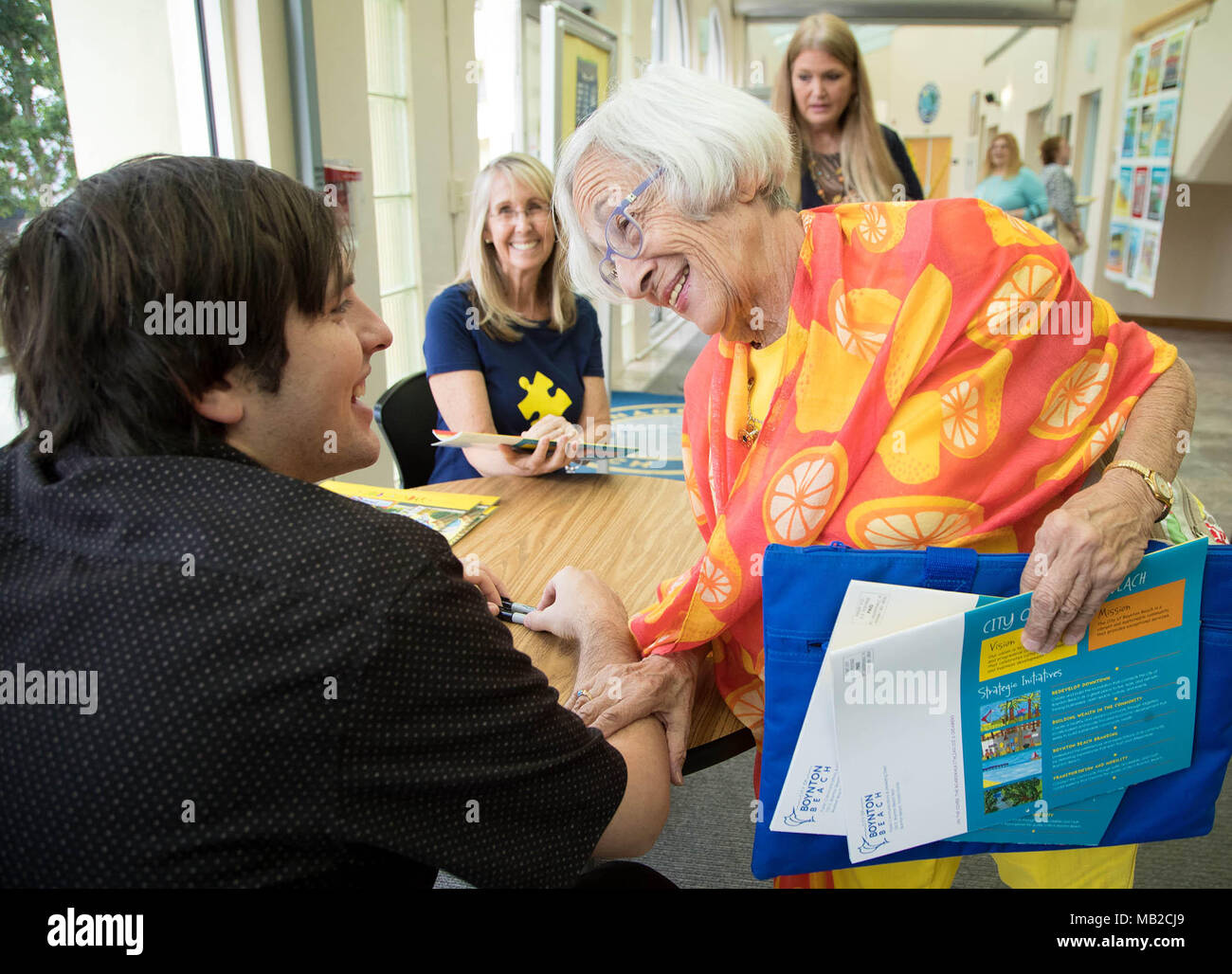 Boynton Beach, Florida, Stati Uniti d'America. 6 apr, 2018. Suburban Boynton resident Jane Burke (destra) grazie Brandon Drucker, un artista che ha autismo e le cui immagini riempire questo anno la città di Boynton Beach calendario. Burke ha fatte a mano un quilt ispirato da Drucker di artwork e vuole insegnare agli altri con autismo come rendere le trapunte in Boynton Beach, Florida il 5 aprile 2018. Credito: Allen Eyestone/Palm Beach post/ZUMA filo/Alamy Live News Foto Stock