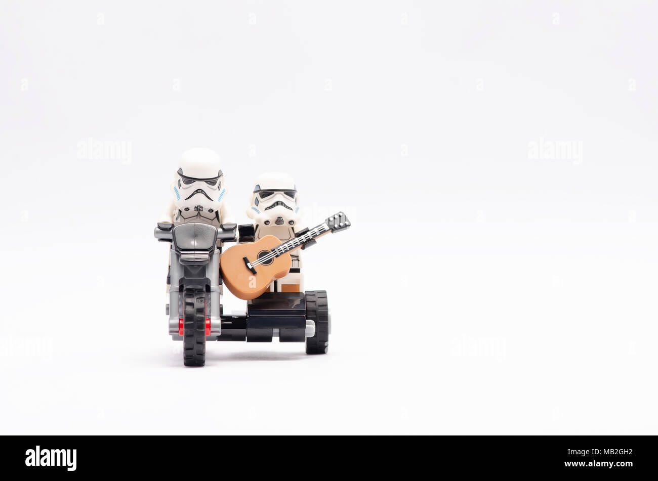La mini figura di storm troopers equitazione e uno di essi tenendo una chitarra in sella motocicletta. Lego minifigures sono fabbricati da Lego. Foto Stock