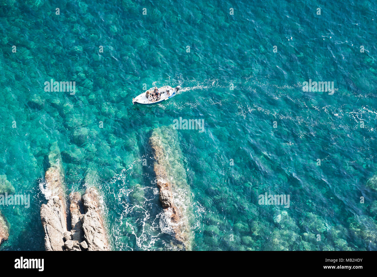 Barca a esplorare le Cinque Terre e le acque cristalline dell'Italia del litorale Foto Stock