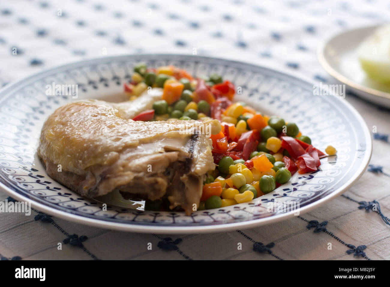 Servito pollo grigliato gamba con verdure su piastra di bianco con decorazioni blu Foto Stock