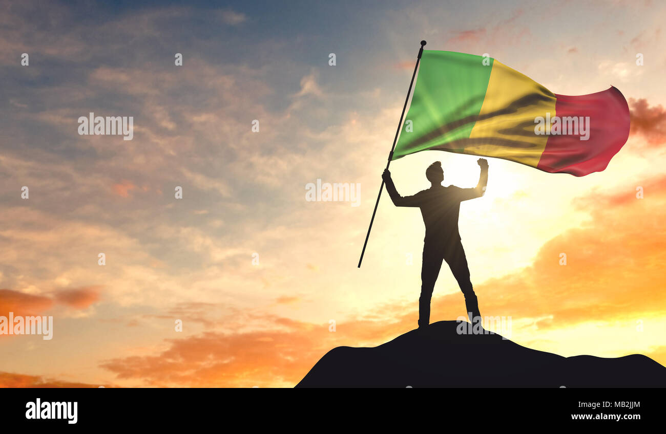 Mali bandiera sventolate da un uomo di celebrare il successo alla sommità di una montagna. Il rendering 3D Foto Stock