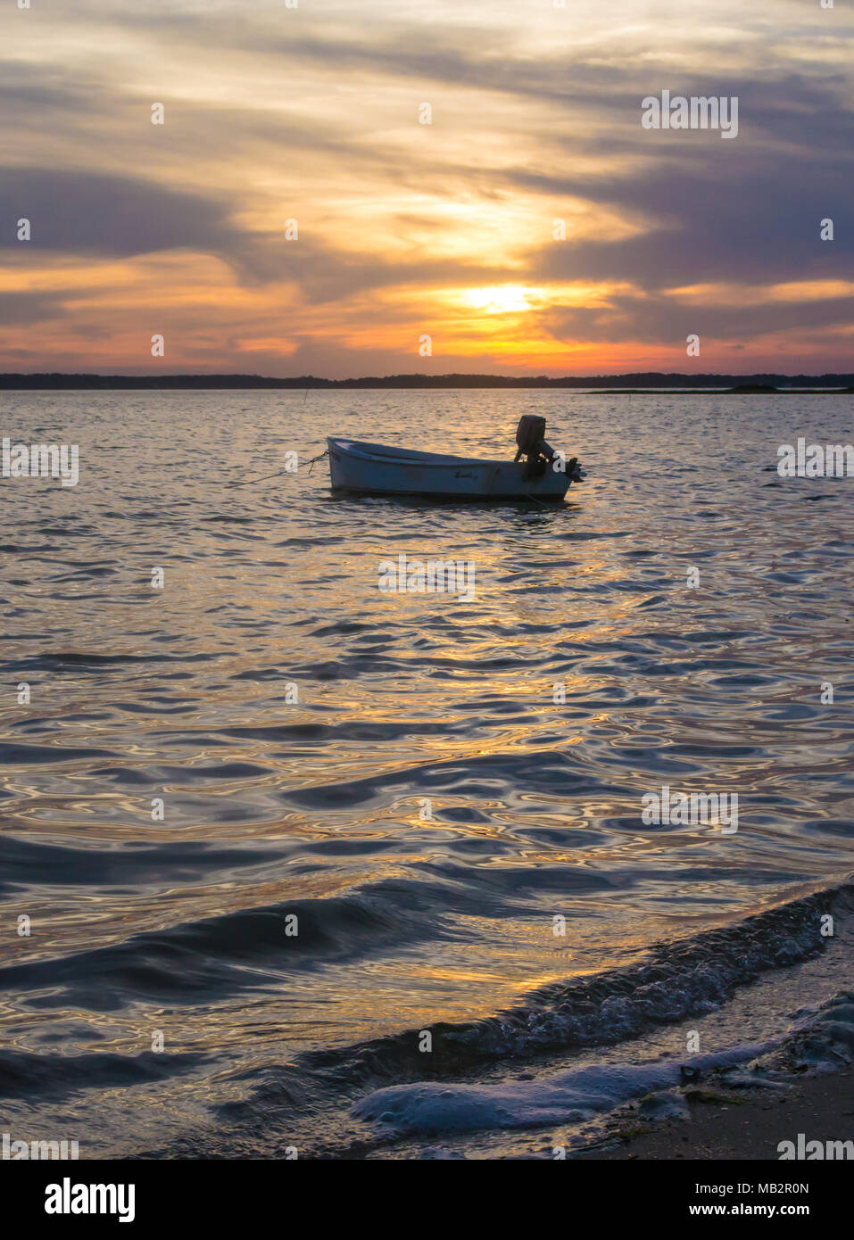 Singolo battello al tramonto, oscillare delicatamente nelle acque del suono. Appena fuori della Harkers Isola, North Carolina. La barca vi aspetta il pescatore Foto Stock