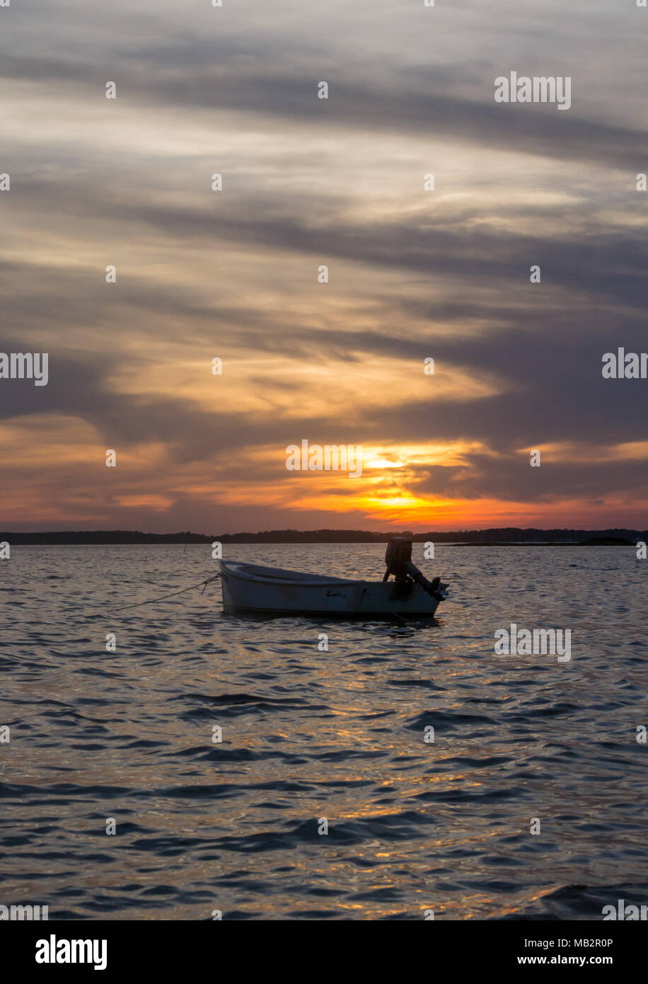 Singolo battello al tramonto, oscillare delicatamente nelle acque del suono. Appena fuori della Harkers Isola, North Carolina. La barca vi aspetta il pescatore Foto Stock