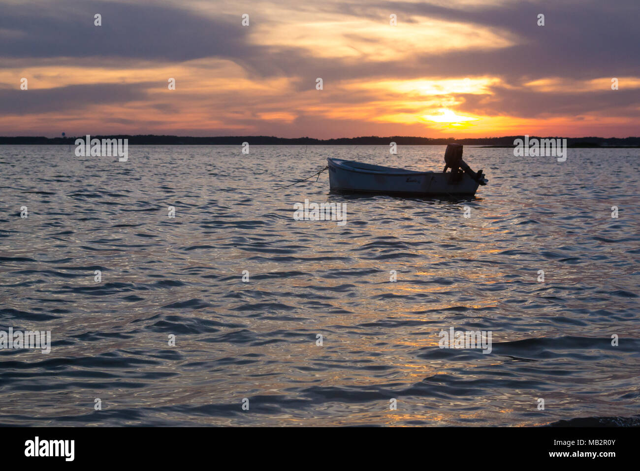 Singolo battello al tramonto, oscillare delicatamente nelle acque del suono. Appena fuori della Harkers Isola, North Carolina. La barca vi aspetta il pescatore Foto Stock
