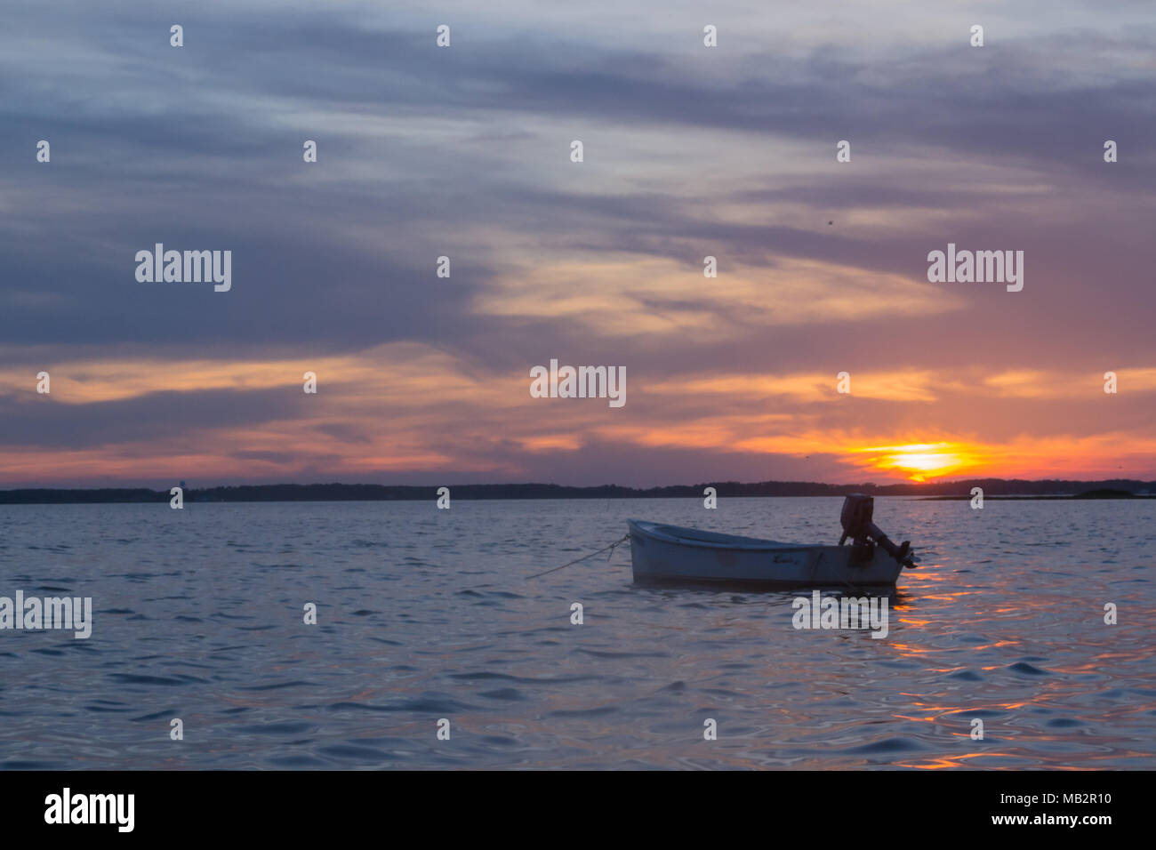 Singolo battello al tramonto, oscillare delicatamente nelle acque del suono. Appena fuori della Harkers Isola, North Carolina. La barca vi aspetta il pescatore Foto Stock