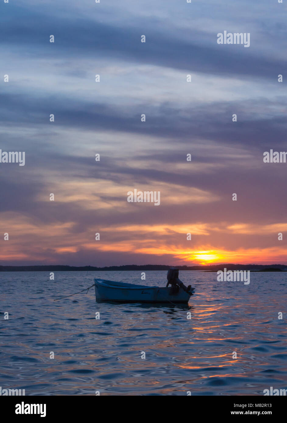 Singolo battello al tramonto, oscillare delicatamente nelle acque del suono. Appena fuori della Harkers Isola, North Carolina. La barca vi aspetta il pescatore Foto Stock