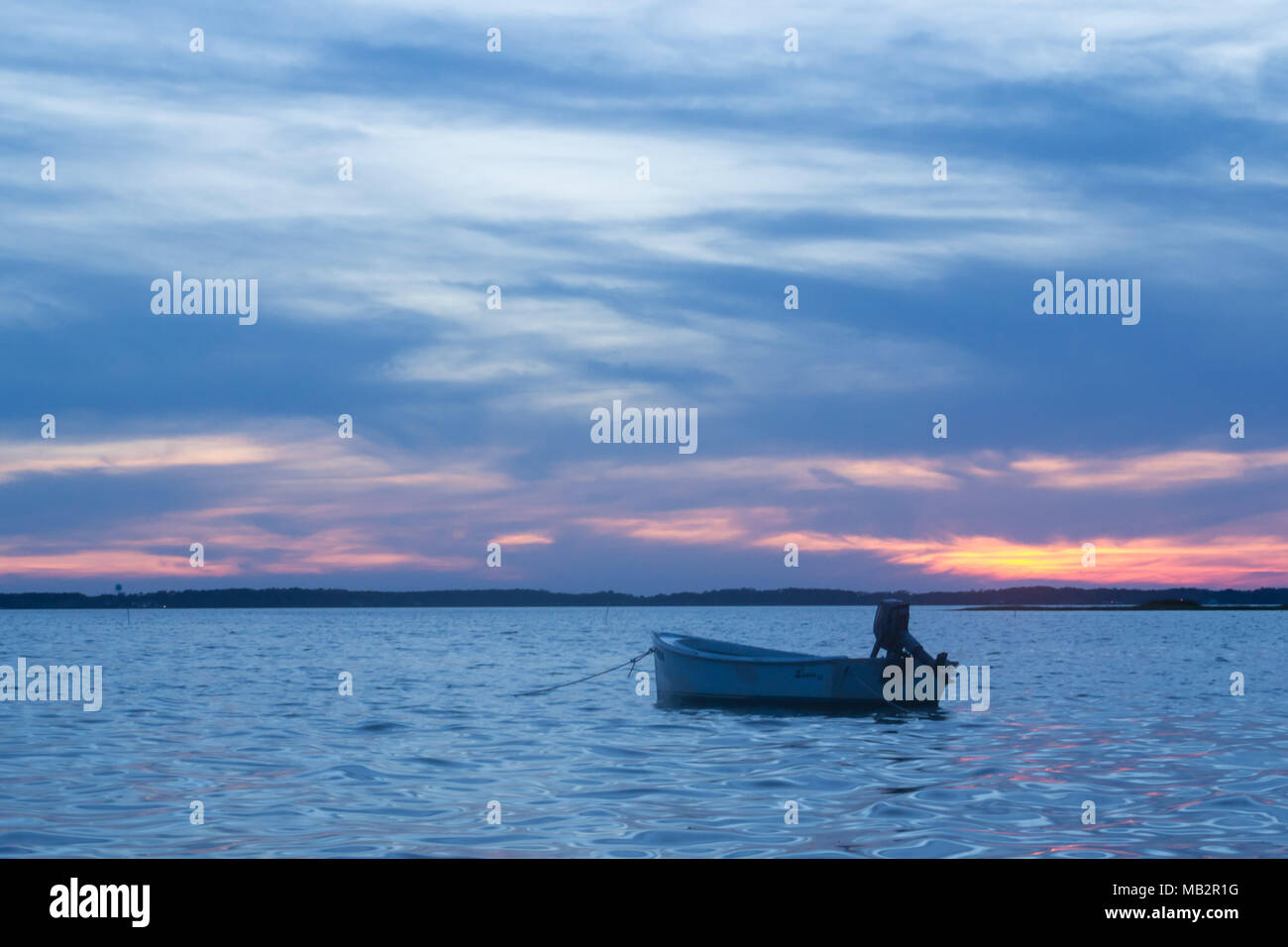 Singolo battello al tramonto, oscillare delicatamente nelle acque del suono. Appena fuori della Harkers Isola, North Carolina. La barca vi aspetta il pescatore Foto Stock