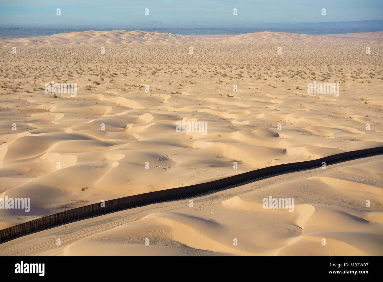 VISTA AEREA. Confine internazionale tra il Messico (dietro il muro) e gli Stati Uniti. Dune di Algodones, deserto di sonora, Baja California, Messico. Foto Stock