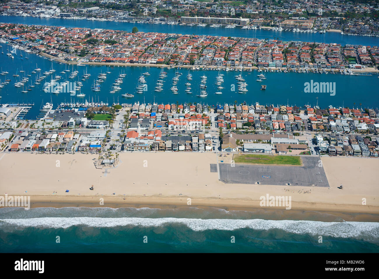 VISTA AEREA. Penisola di Balboa in primo piano con Lido Isle tra i due corsi d'acqua. Newport Beach, Orange County, California, USA. Foto Stock
