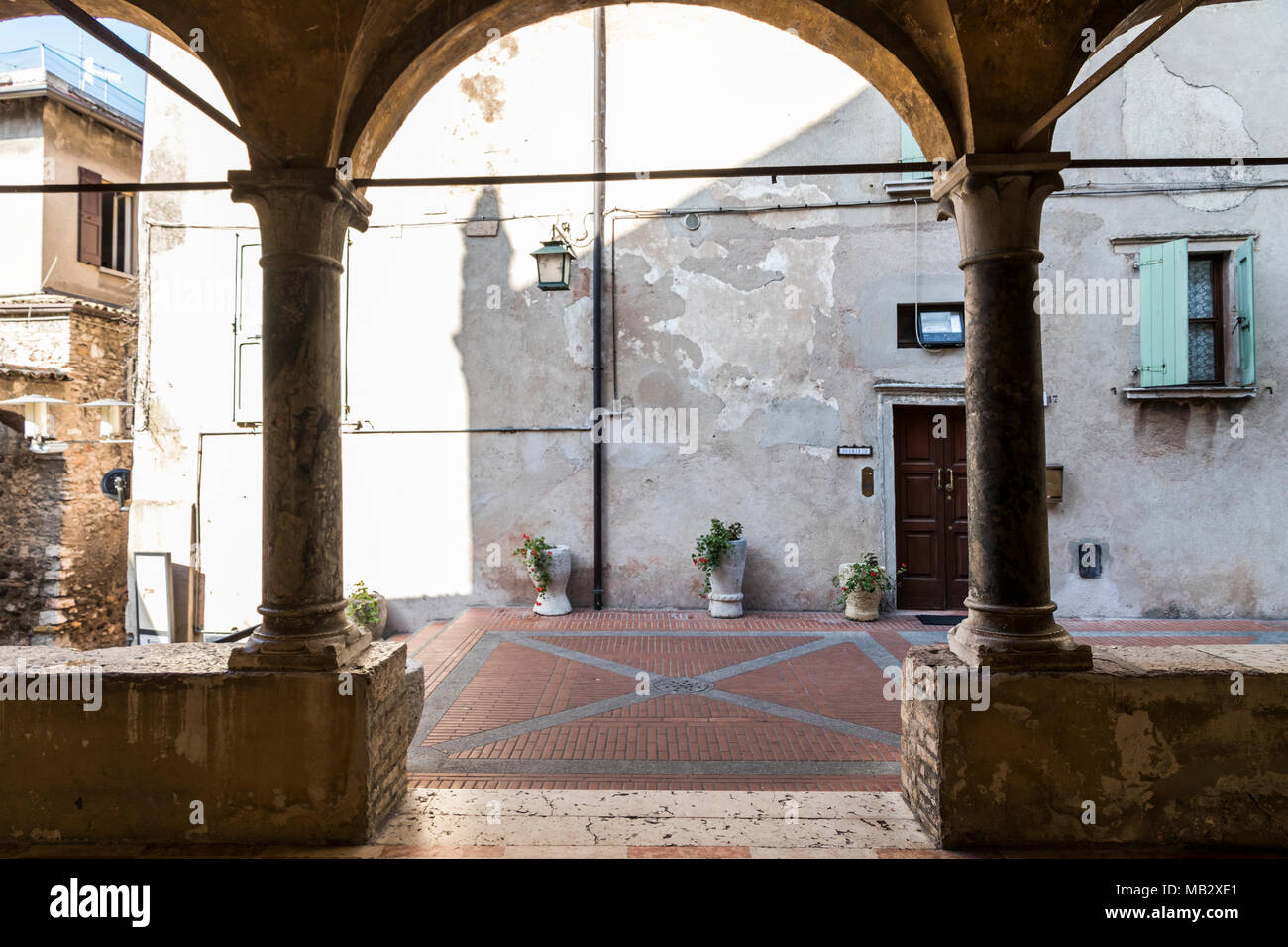 Sirmione, Italia. Ingresso porticato della chiesa di Santa Maria Maggiore o della neve, la chiesa parrocchiale della cittadina e la penisola di Sirmione, provi Foto Stock