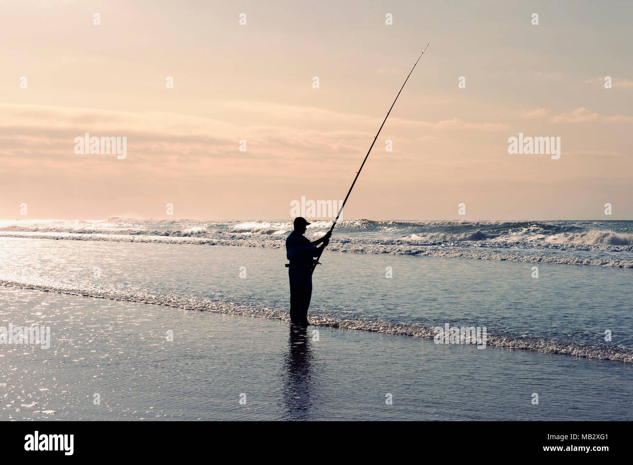 Durban, Sud Africa - 25. Giugno 2017: pescatore la pesca su una spiaggia da sola in Santa Lucia, Hluhluwe National Park, vicino a Durban. Foto Stock