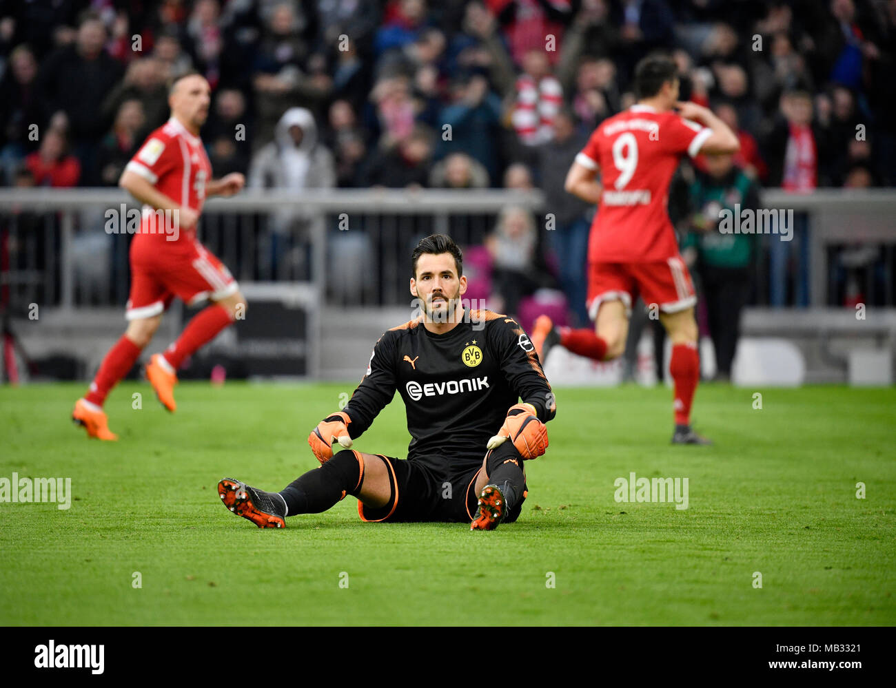 Il portiere Roman Bürki Borussia Dortmund deluso dopo ammettendo obiettivo, Bayern giocatori allietare in background Foto Stock