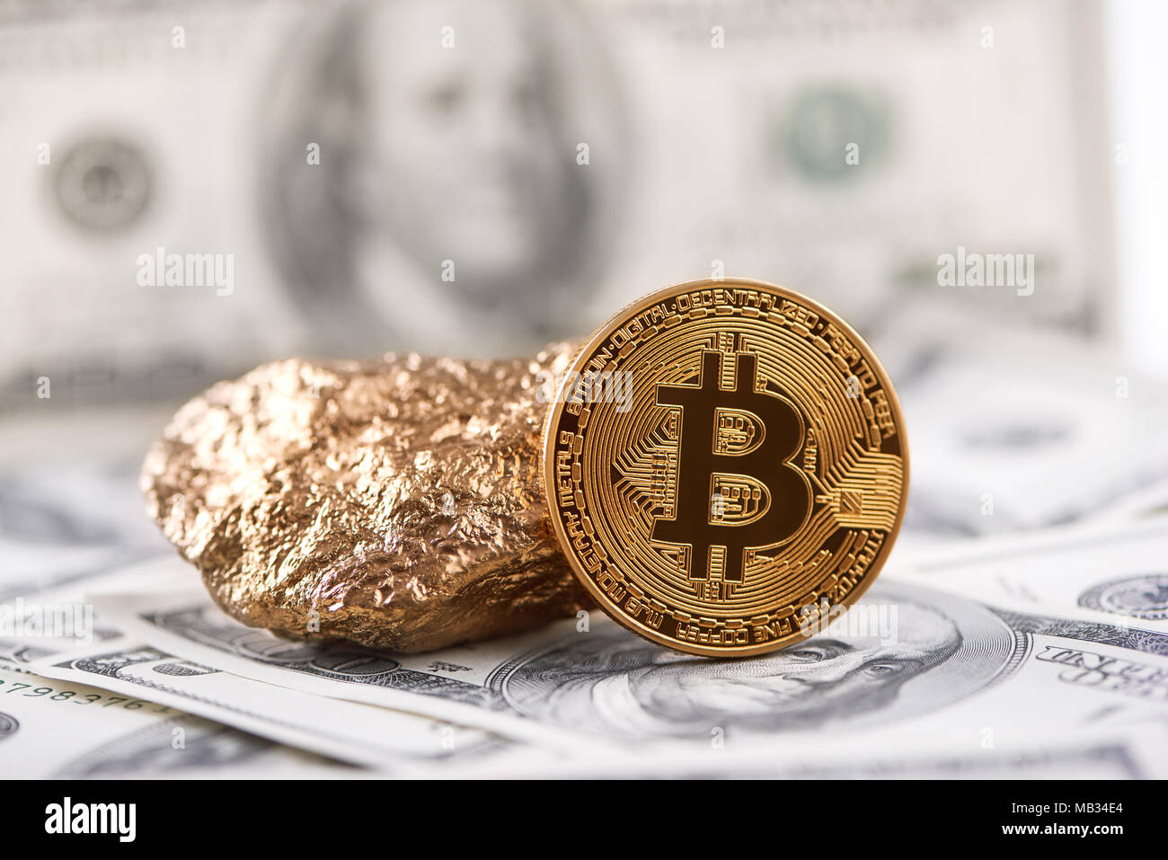 Golden bitcoin come principale cryptocurrency mondiale e oro grumo presentato sulla banconota del dollaro di sfondo. Trend futuristico digitale blockchain virtual denaro elettronico valuta web mining business exchange Foto Stock