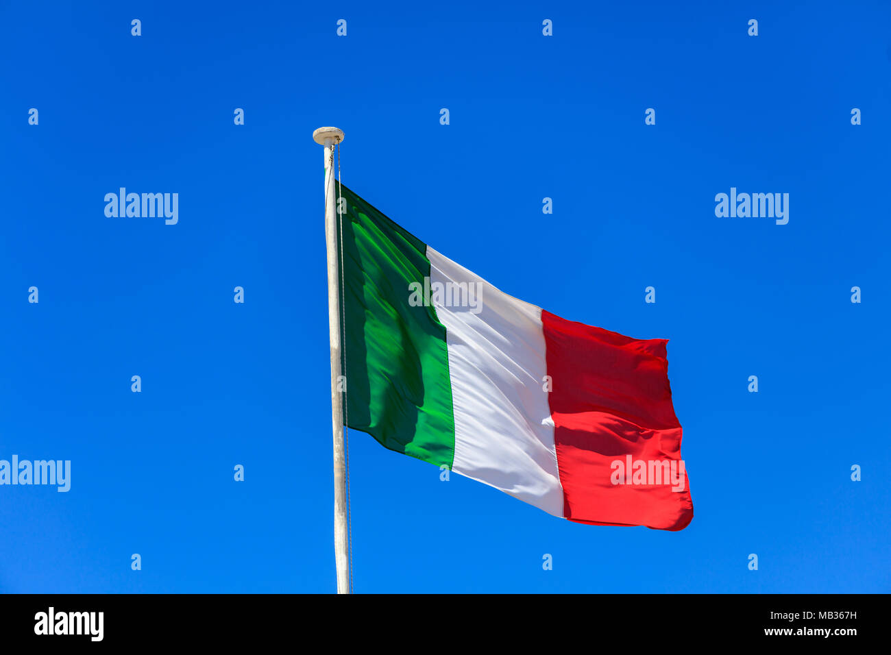 Bandiera dell'Italia. Bandiera italiana su un pennone sventola su un luminoso cielo blu sullo sfondo Foto Stock