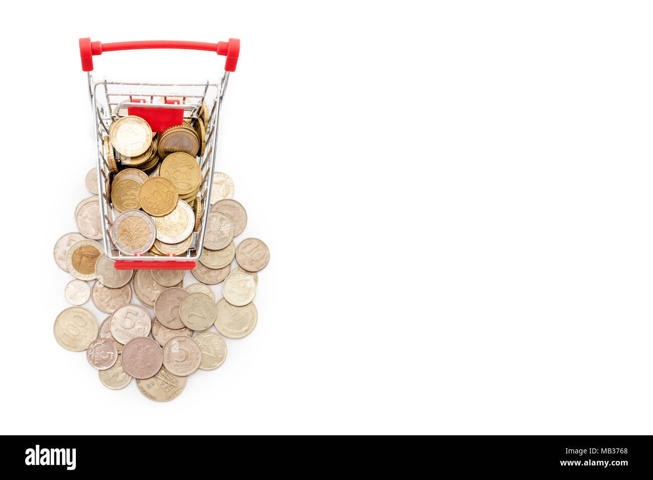 Carrello con monete in euro è in sella a una pila di vecchie e arrugginite monete russe su sfondo bianco. Spazio libero per il testo. Foto Stock