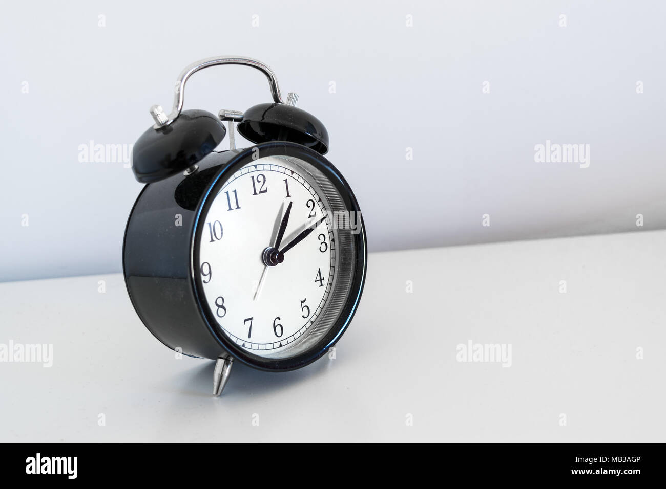 Allarme tradizionale orologio su una tabella su sfondo bianco Foto Stock