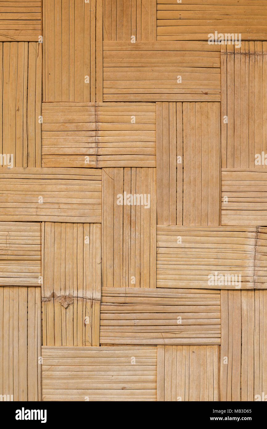 Telaio completo sullo sfondo di un tessuto di parete di bambù nel disegno a spina di pesce con toni caldi Foto Stock