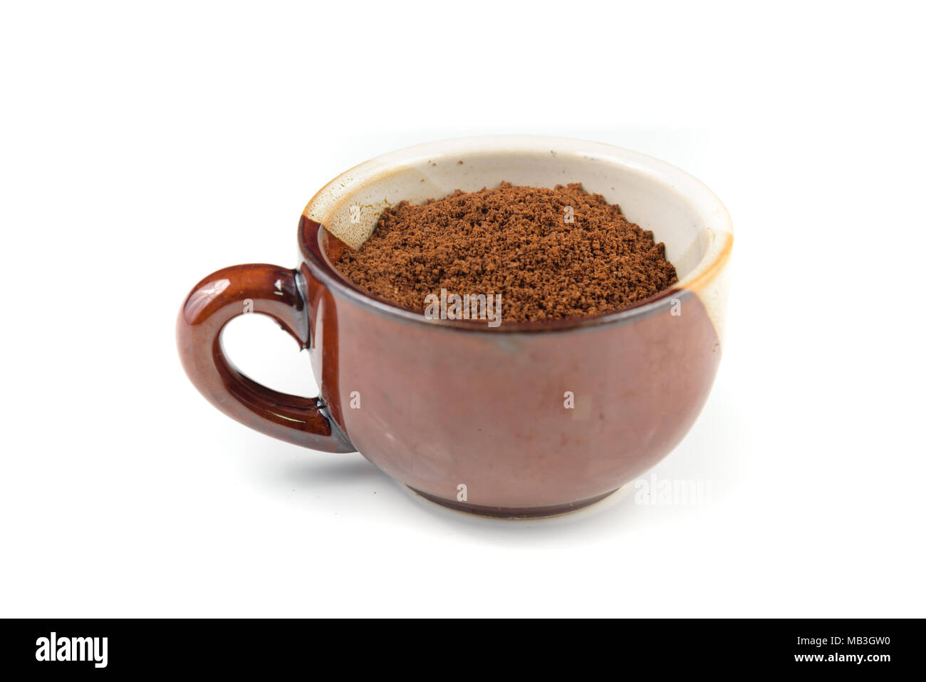 Una ceramica tazza da caffè espresso piena di caffè appena macinato Foto Stock