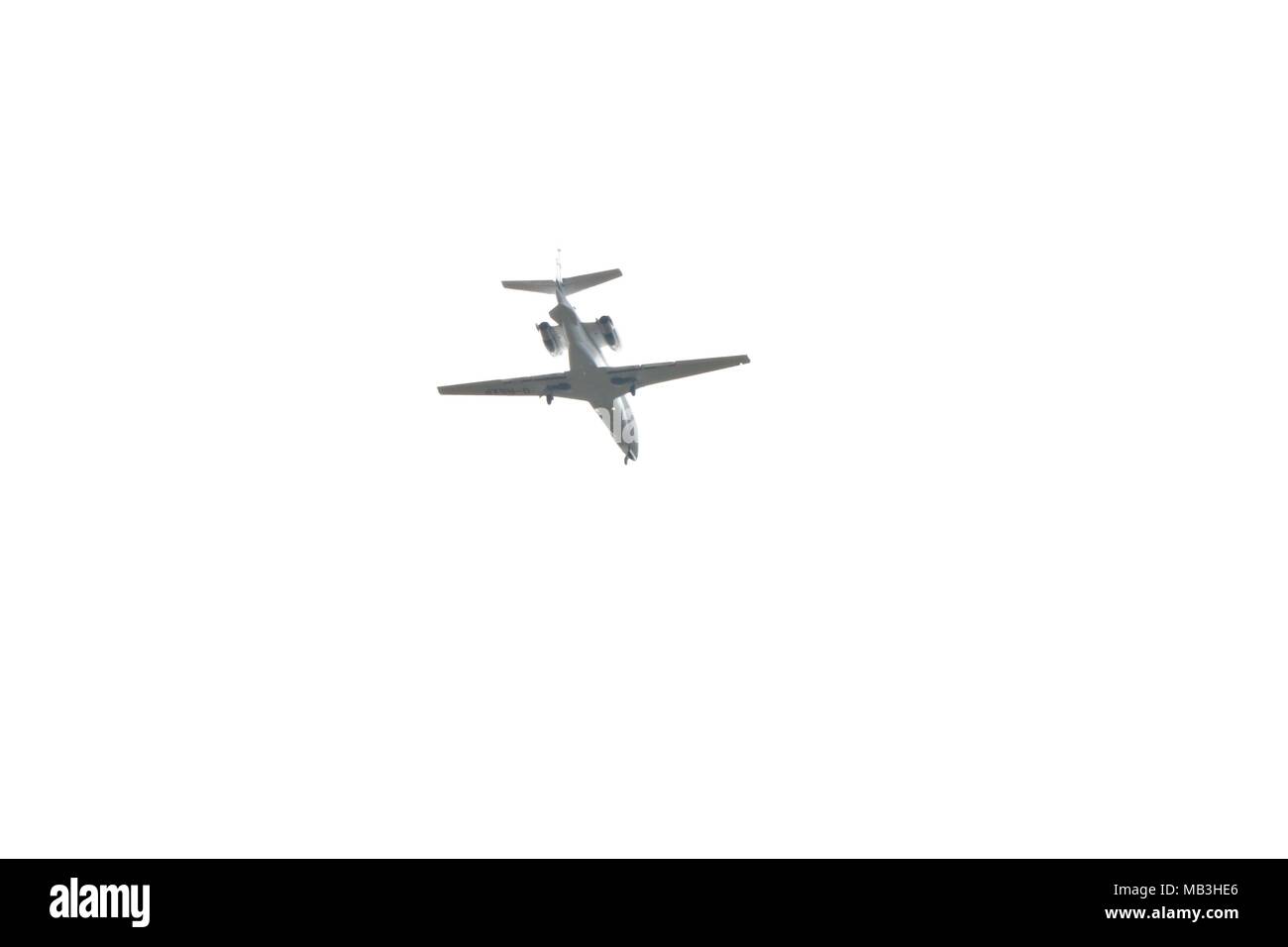 Vista del lato inferiore di aereo in volo contro un bianco cielo molto nuvoloso Foto Stock