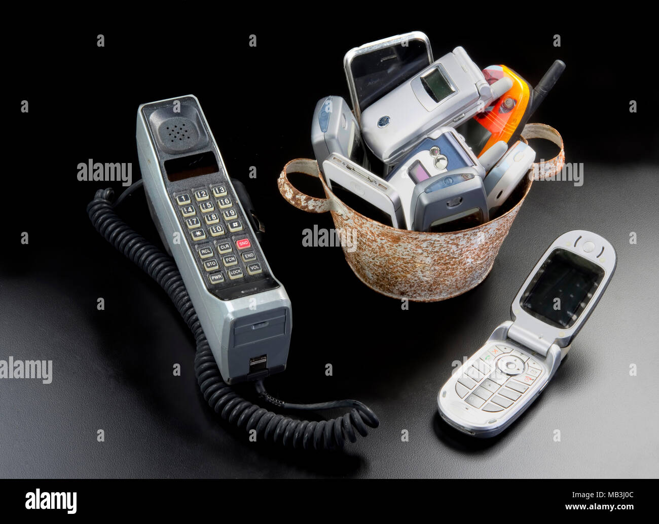 Benna e tavolo pieno di vecchi telefoni cellulari. Foto Stock
