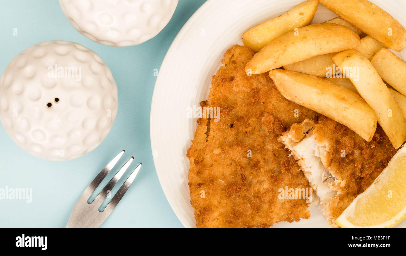 Popolare tradizionale pesce e patatine contro uno sfondo blu Foto Stock