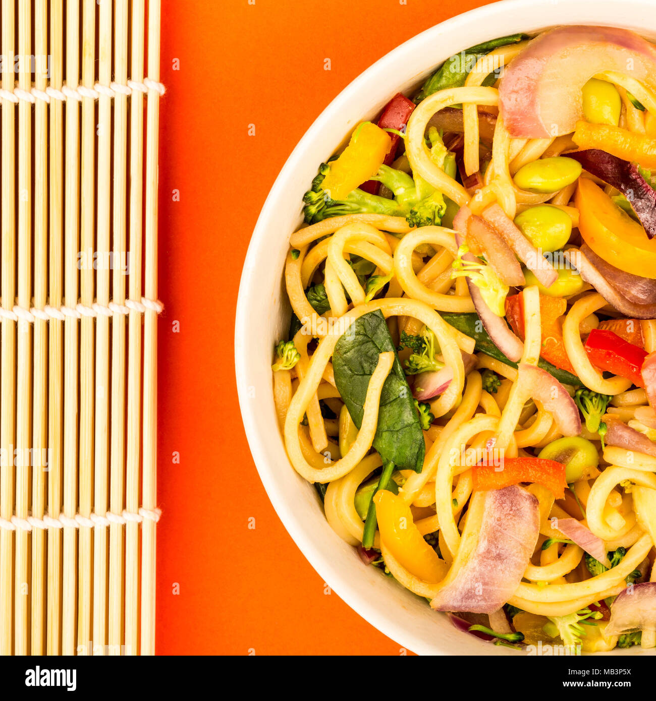 Mescolare uovo fritto Tagliatelle con verdure fresche Sfondo rosso Foto Stock
