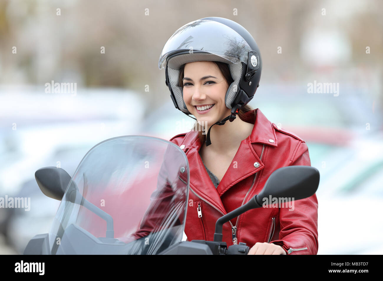 Felice biker seduto su una moto che vi guardano sulla strada Foto Stock
