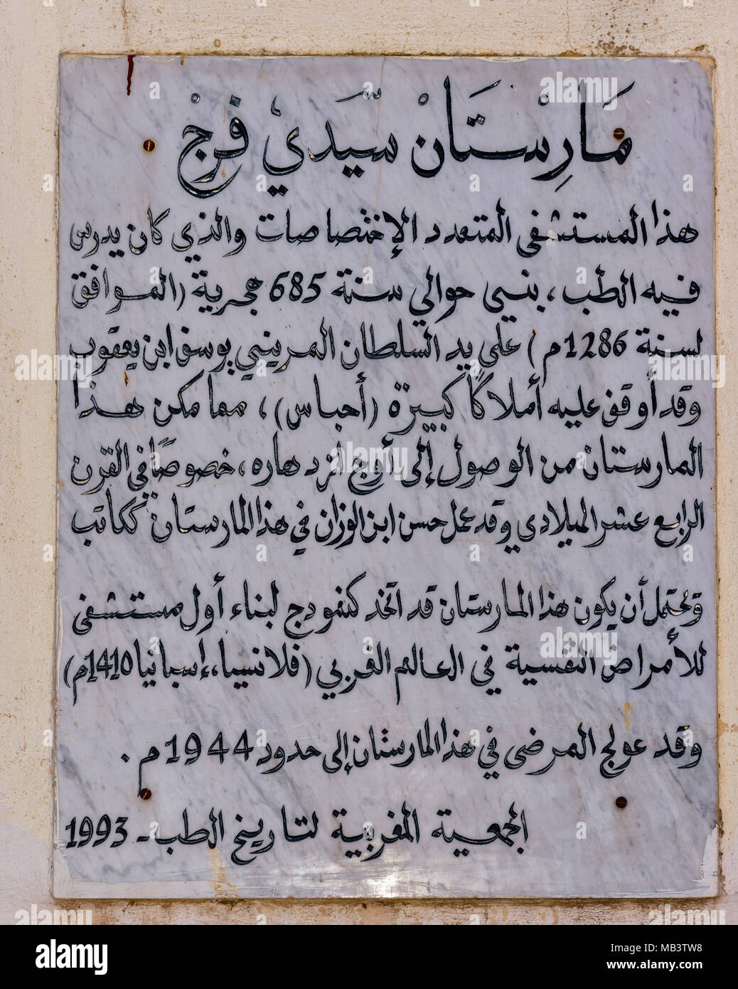 Il Marocco FES MEDINA SOUK AVVISO SULLA PARETE AL DI FUORI DELL'OSPEDALE MARISTAN SIDI FREJ IN ARABO Foto Stock