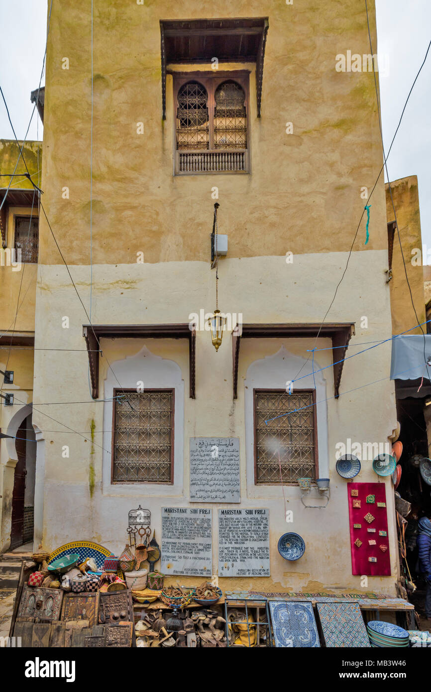 Il Marocco FES MEDINA SOUK PARETE DEL MARISTAN SIDI FREJ OSPEDALE CON PLACCHE O AVVISI E ARTICOLI PER LA VENDITA Foto Stock