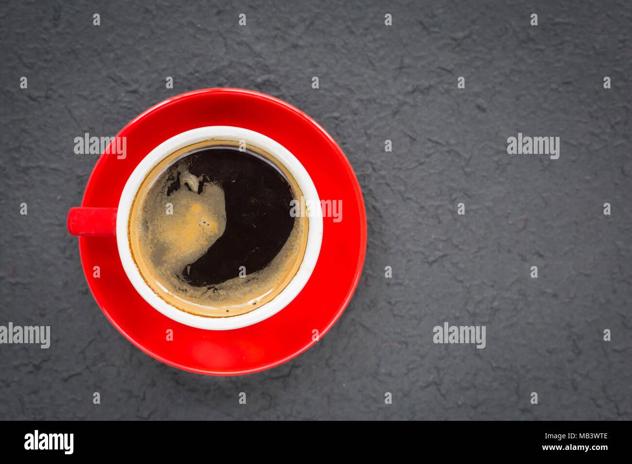Un rosso tazza di caffè sul colore nero terra Foto Stock
