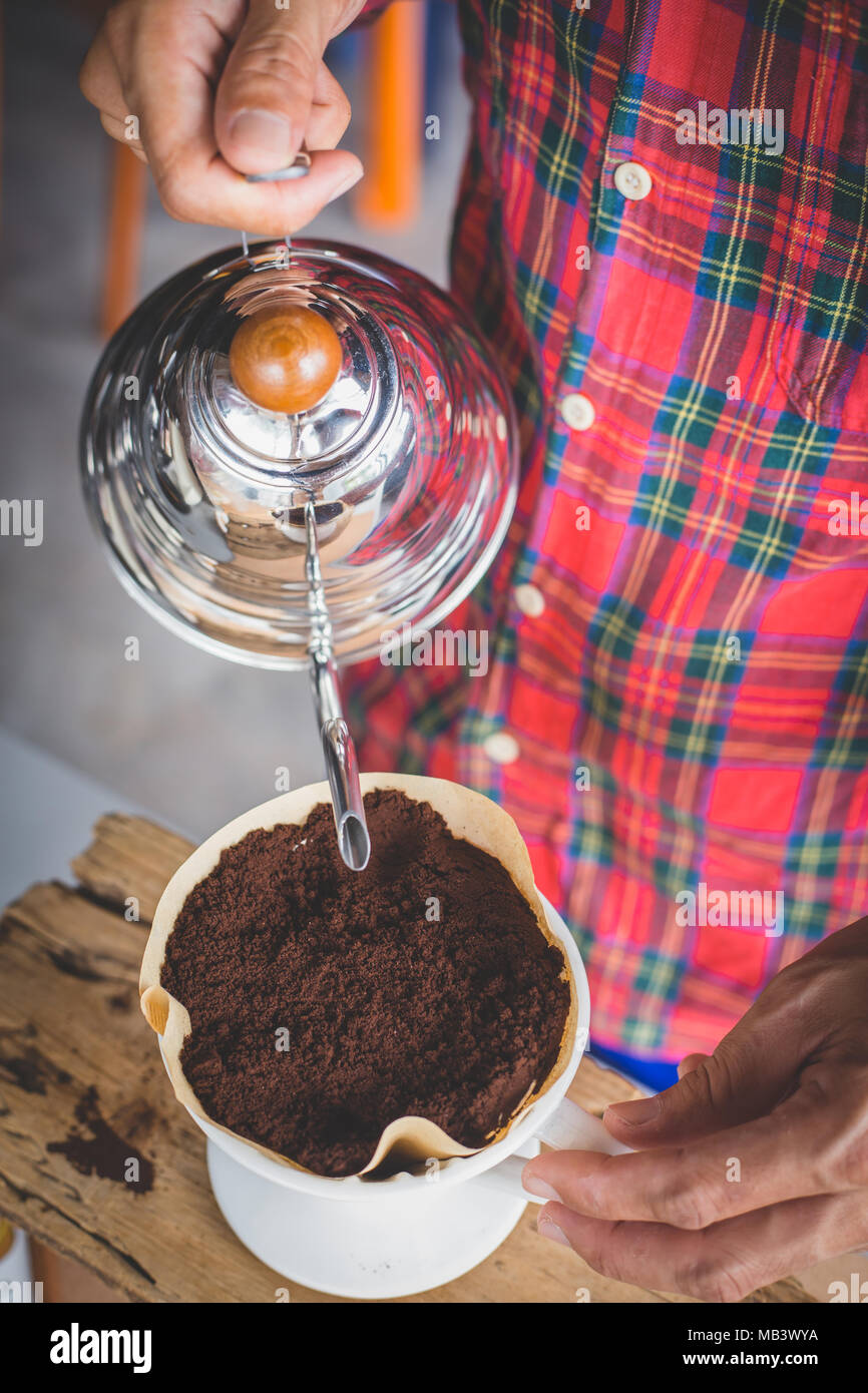 Mano caffè antigoccia , Barista versando acqua sul caffè macinato con filtro Foto Stock