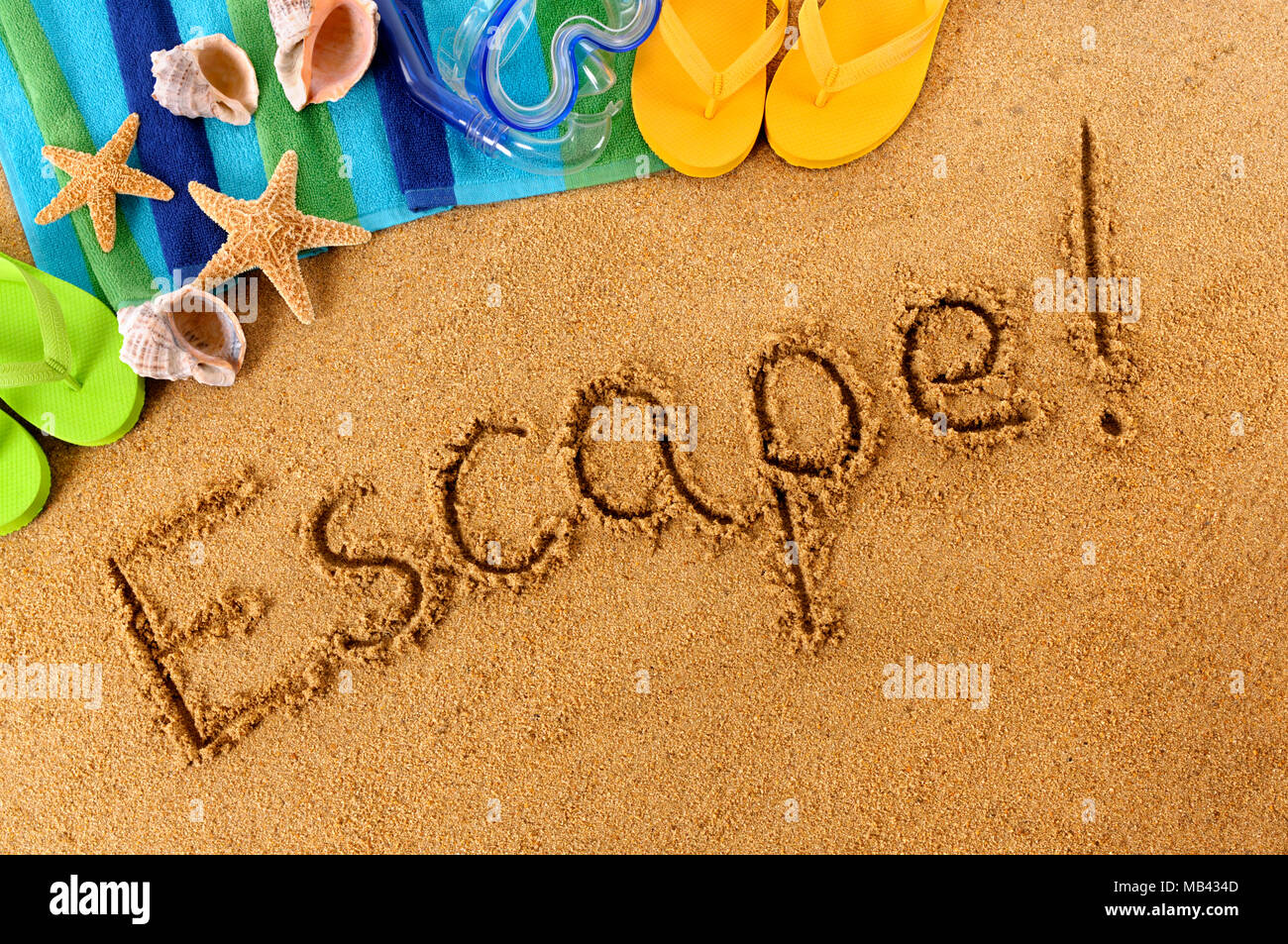 La parola fuga! Scritto su di una spiaggia di sabbia, con Scuba Mask, telo mare, stelle marine e flip flop Foto Stock