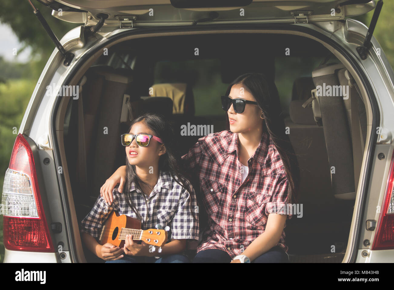 Felice bambina con la famiglia asiatica seduto in macchina per godere di viaggio e la vacanza estiva in camper Foto Stock
