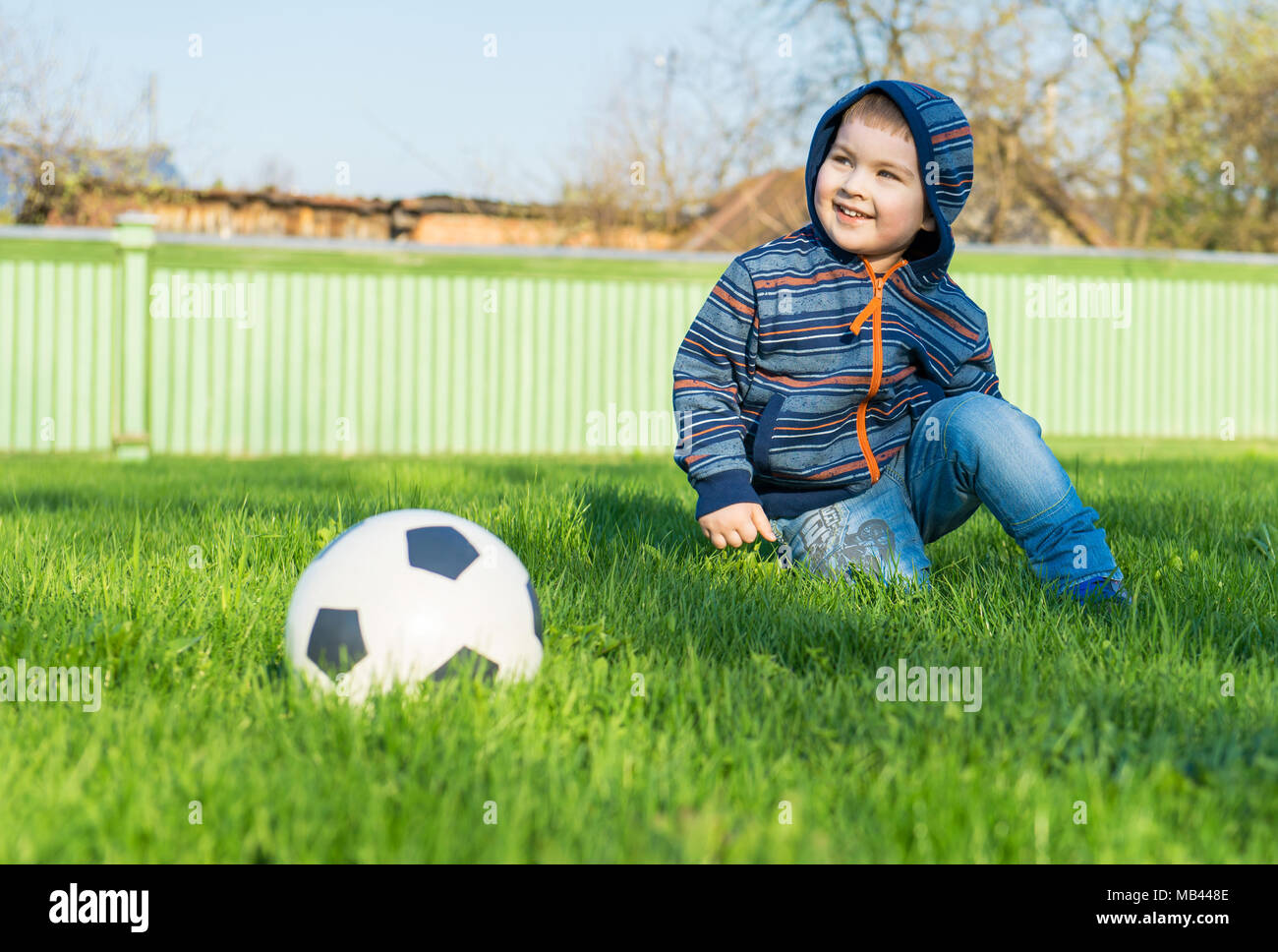 Ragazzo giovane posa su un prato verde. Nelle vicinanze la sfera si trova Foto Stock