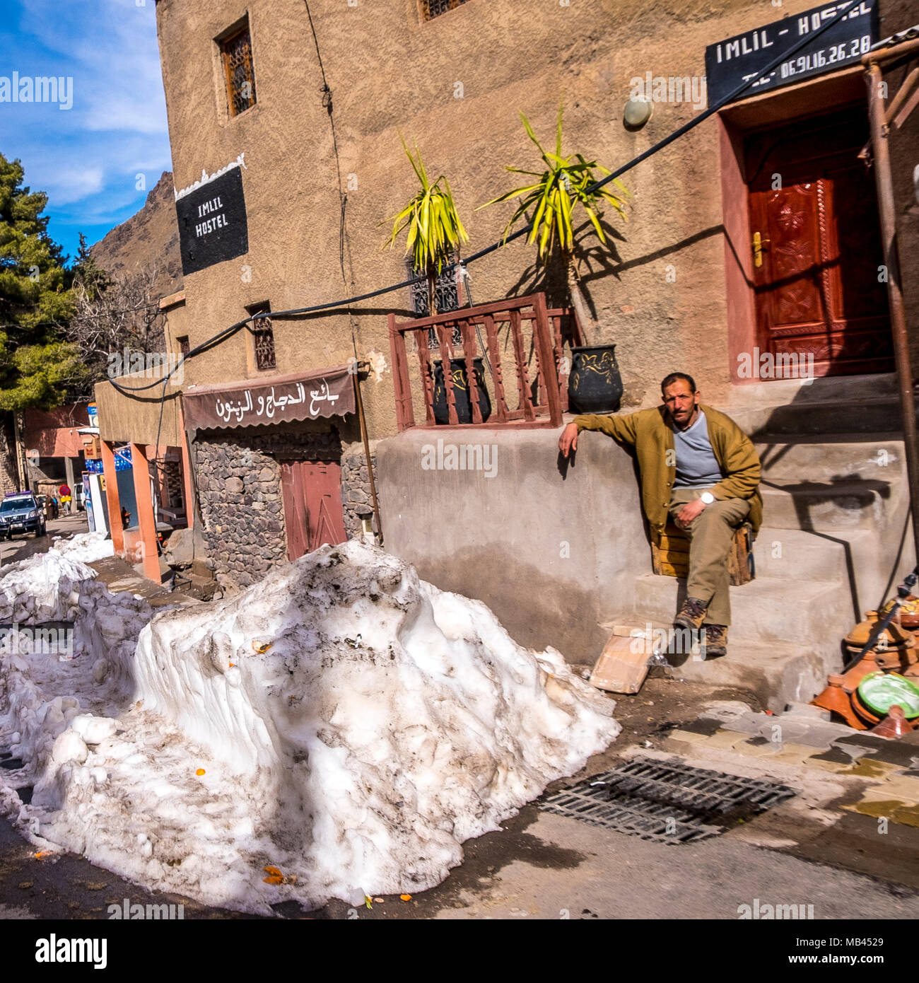 Berber uomo sat da strada in montagne Atlas, Marocco Foto Stock