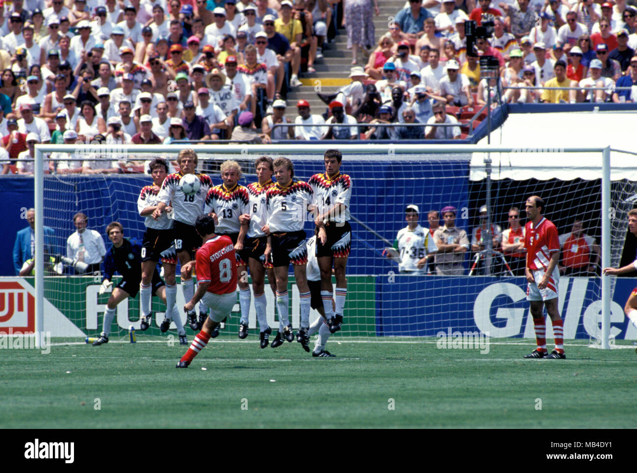 Coppa del Mondo FIFA - USA 1994 10.7.1994, il Giants Stadium di New York e New Jersey. World Cup Quarti di Finale, Bulgaria v Germania. Hristo Stoitchkov (Bulgaria) si piega un freekick oltre la parete tedesco. I giocatori tedeschi da sinistra Lothar Matths, Jurgen Klinsmann, Rudi Vler, Guido Buchwald, Thomas Helmer & Thomas Berthold. Il portiere Bodo Illgner è sulla sua linea, sulla destra Letchkov Iordan (9). Foto Stock