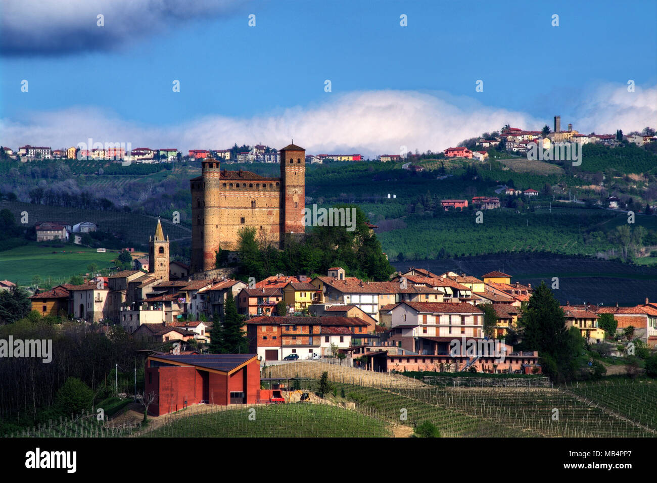 Il castello di Serralunga d'Alba si staglia al di sopra del villaggio. Dietro di lui, oltre quindici chilometri del villaggio di Murazzano con la sua torre medievale Foto Stock