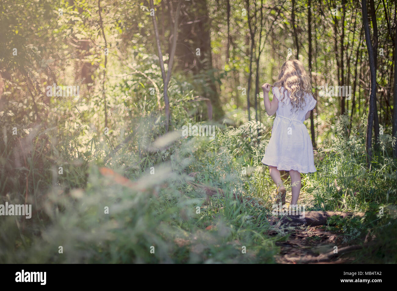 Giovane ragazza bionda passeggiate nella foresta Foto Stock