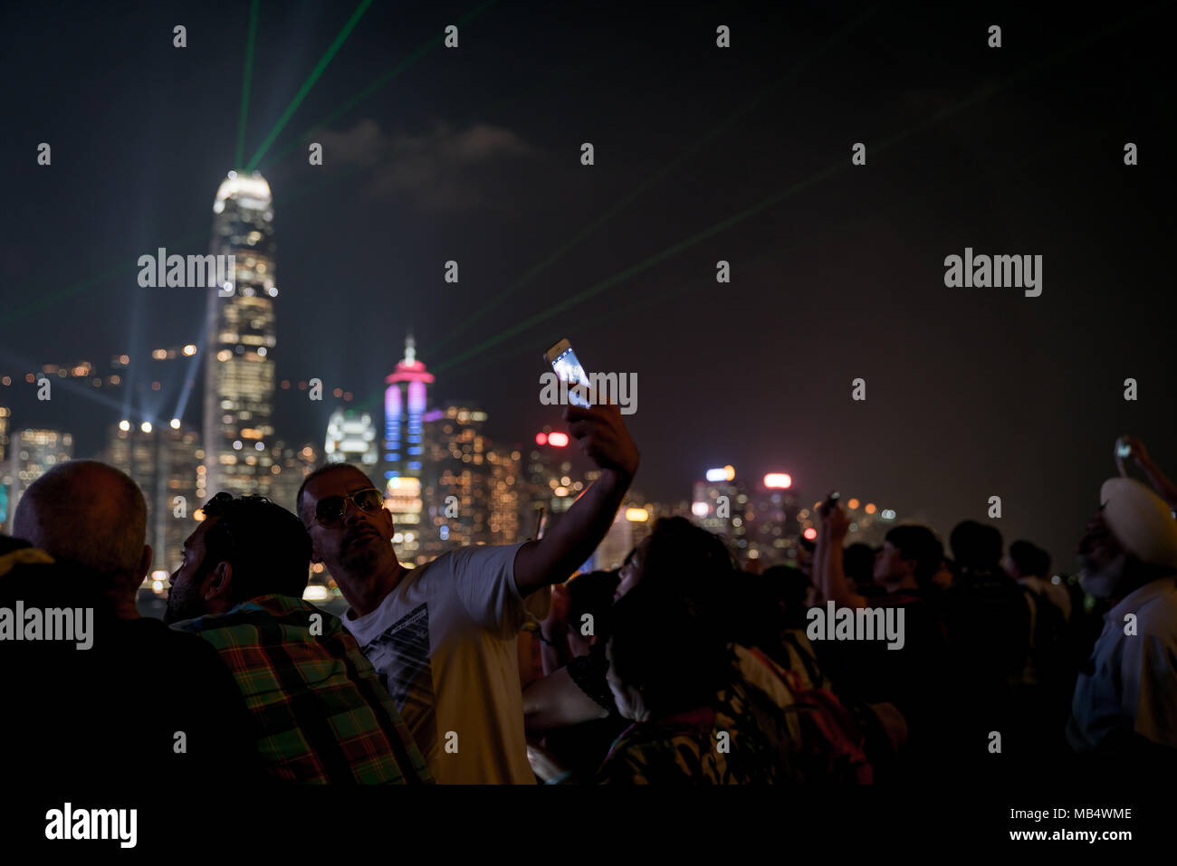 HONG KONG - Settembre 20 2017; sgranate le luci dell'immagine di Hong Kong defocalizzata commerciale bachground skyline di gruppo compresi selfie prendendo l uomo azienda Foto Stock