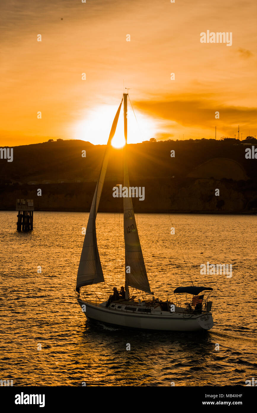 Tranquillo paesaggio con barca a vela vela in oceano contro amber sky al tramonto Foto Stock