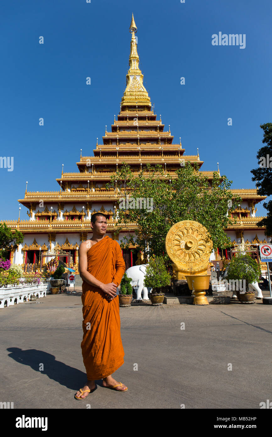 Monaco buddista si erge di fronte a nove piani stupa Phra Mahathat Kaen Kakhon, Wat Nong Waeng tempio, Khon Kaen, Isan, Thailandia Foto Stock