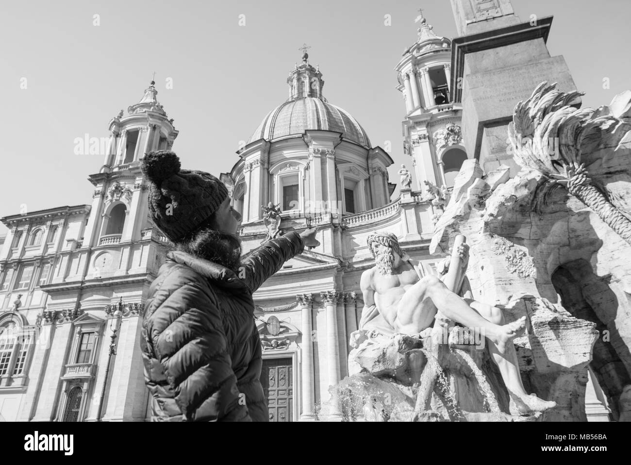 Immagine in bianco e nero di capelli neri donna rivolta verso la scultura a Piazza Navona, importante punto di riferimento di Roma, Italia Foto Stock